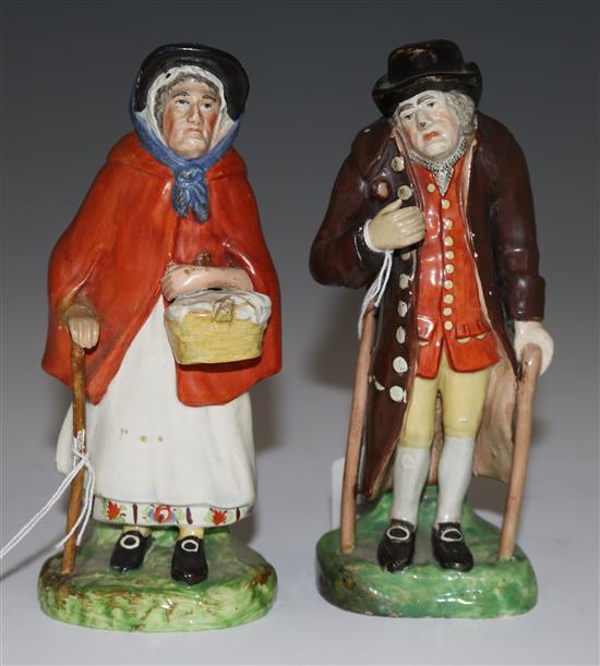 A pair of Staffordshire pearlware figures of an elderly lady and gentleman, c.1830, height 18cm (7.1in.), restorations